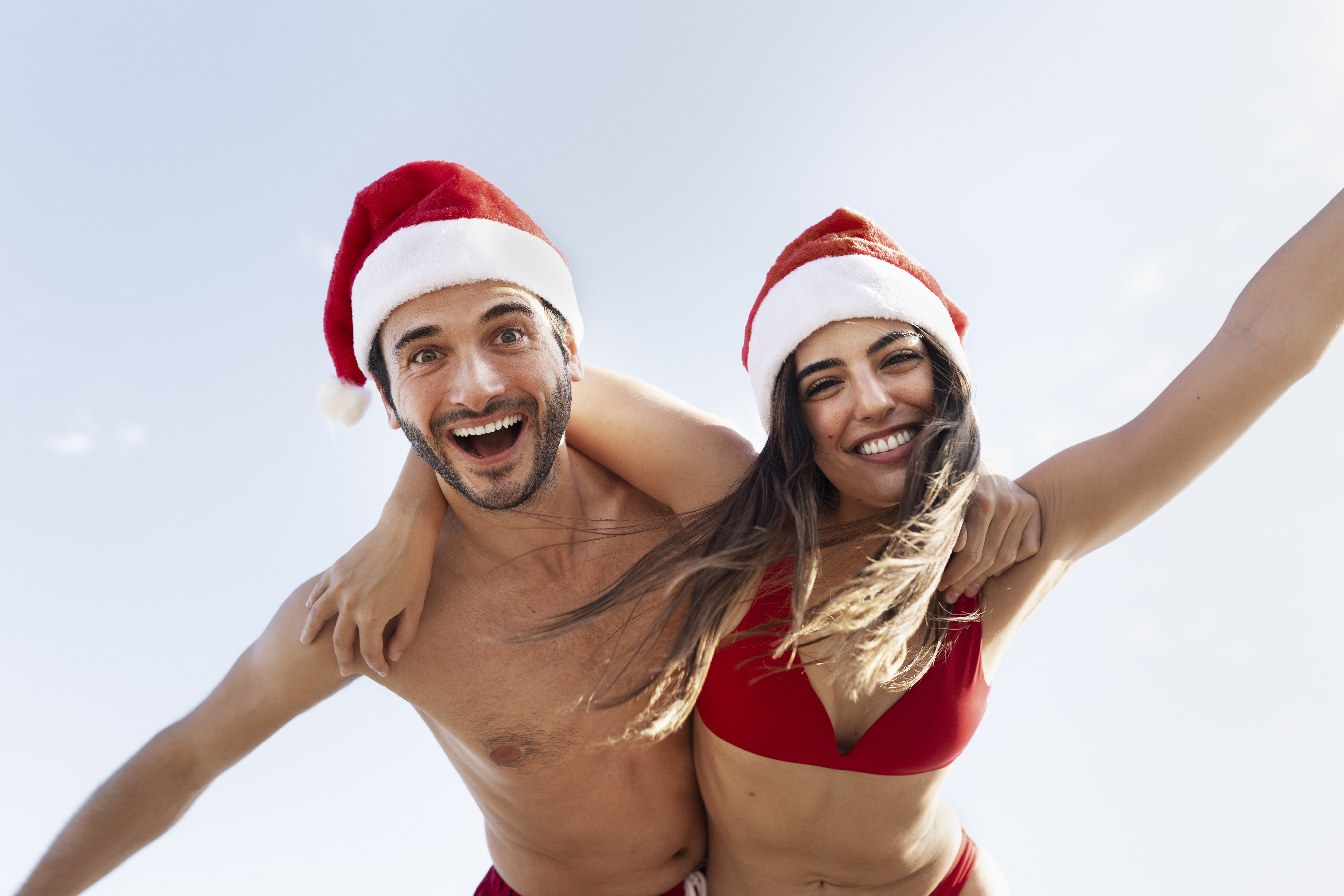 happy-couple-with-santa-hats-low-angle